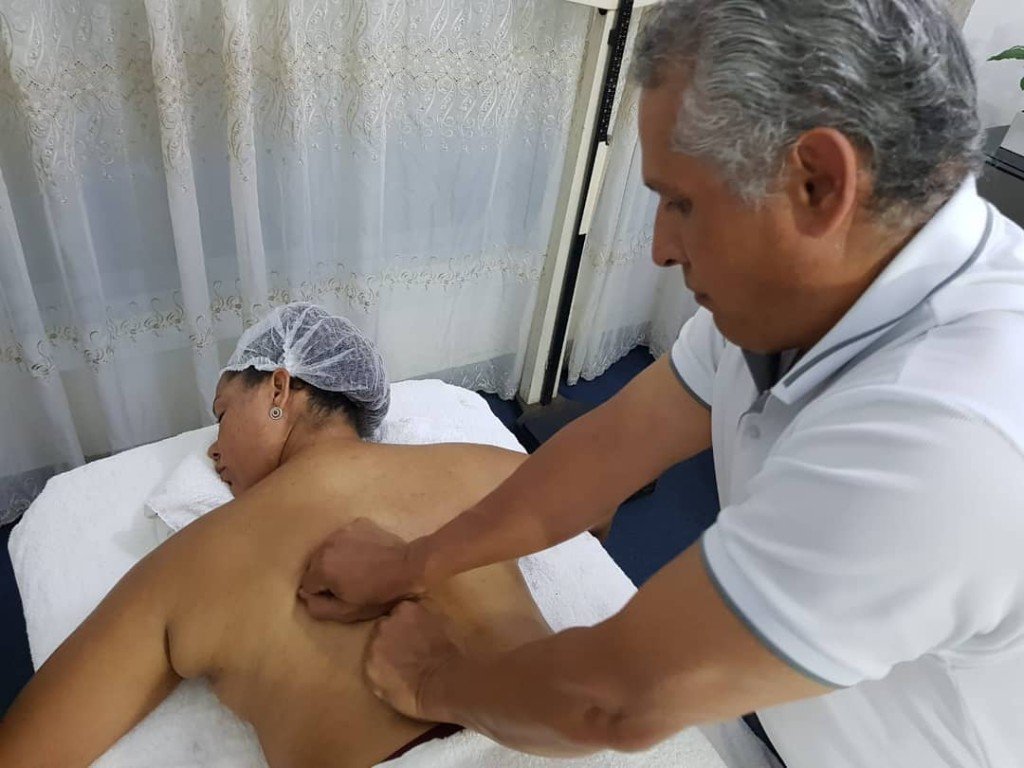 El Dr. Rodríguez De León trabaja con las manos la espalda de una paciente